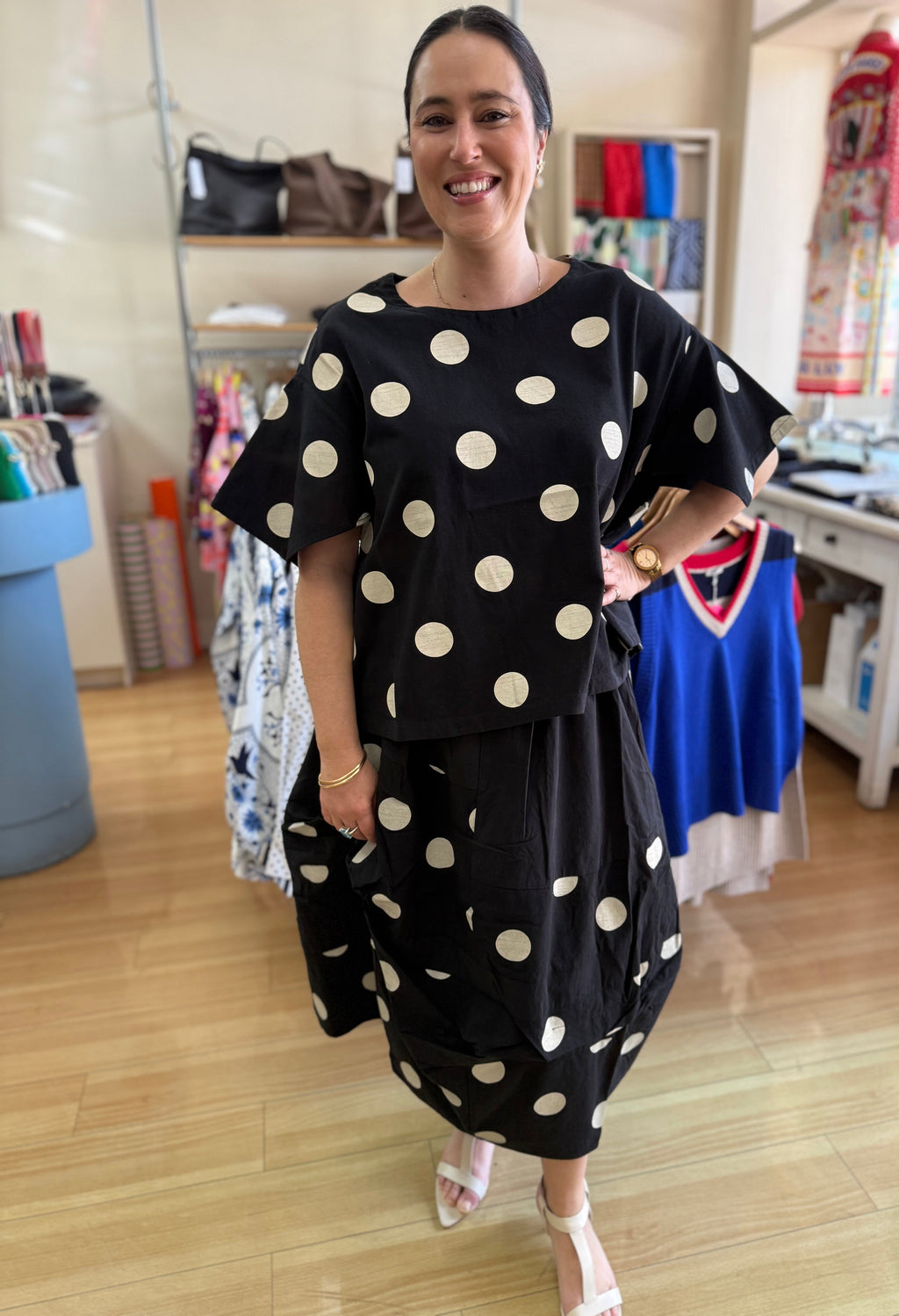 Woman wearing a black polka dot outfit in a store setting